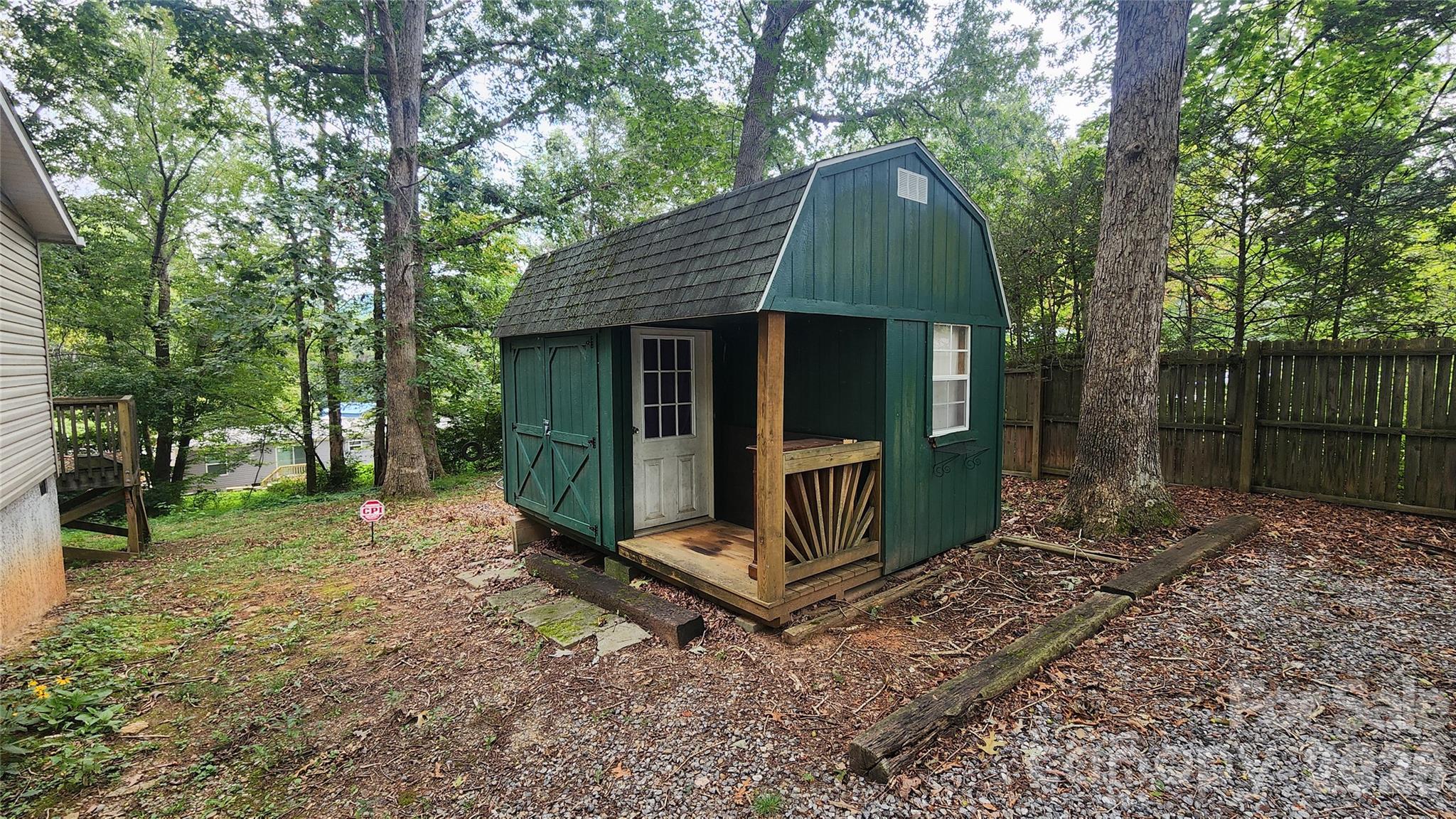 67 Indian Trail Road Candler, NC 28715 - Photo 24 of 31 a view of a small house with a small yard and a large tree