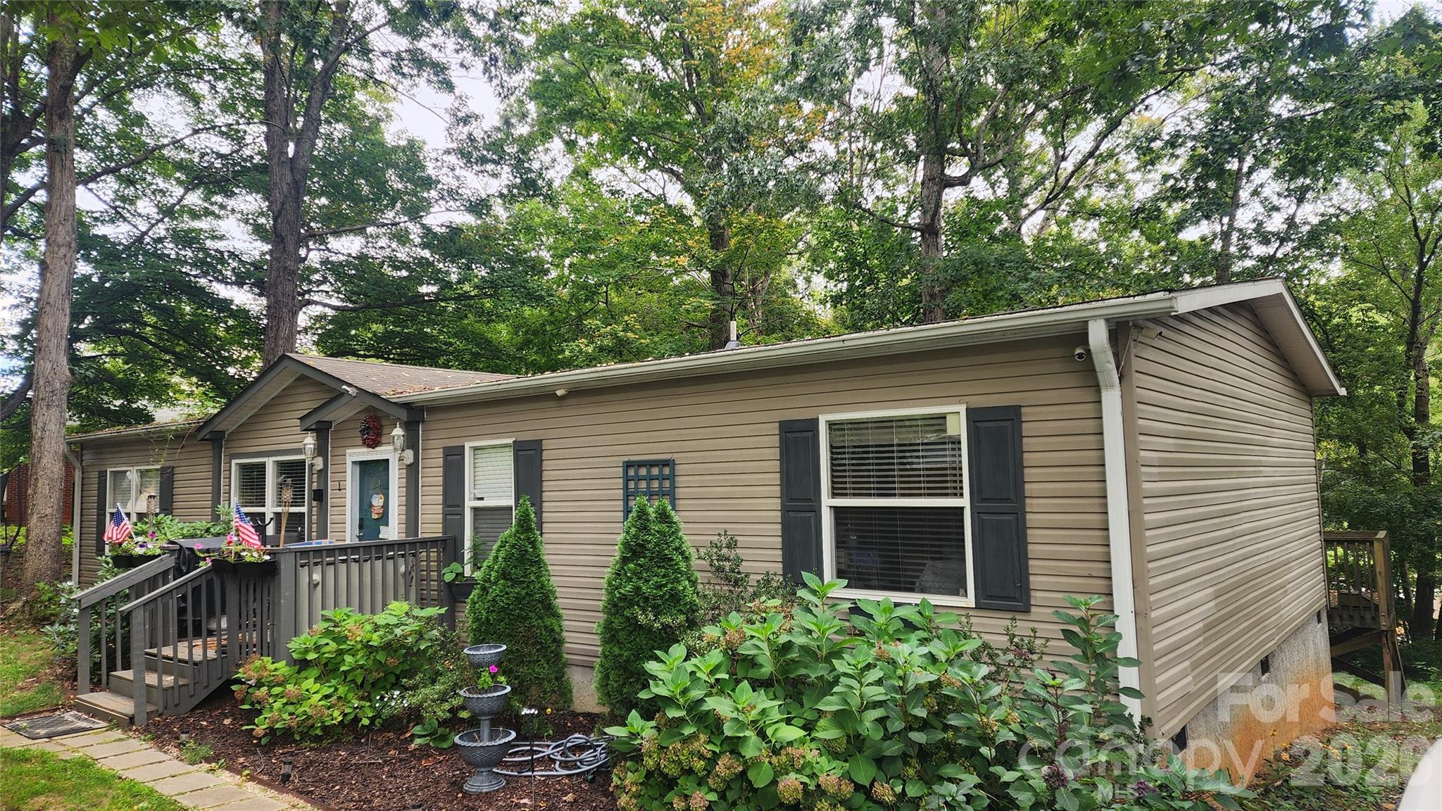67 Indian Trail Road Candler, NC 28715 - Photo 3 of 31 a front view of a house with a yard and potted plants