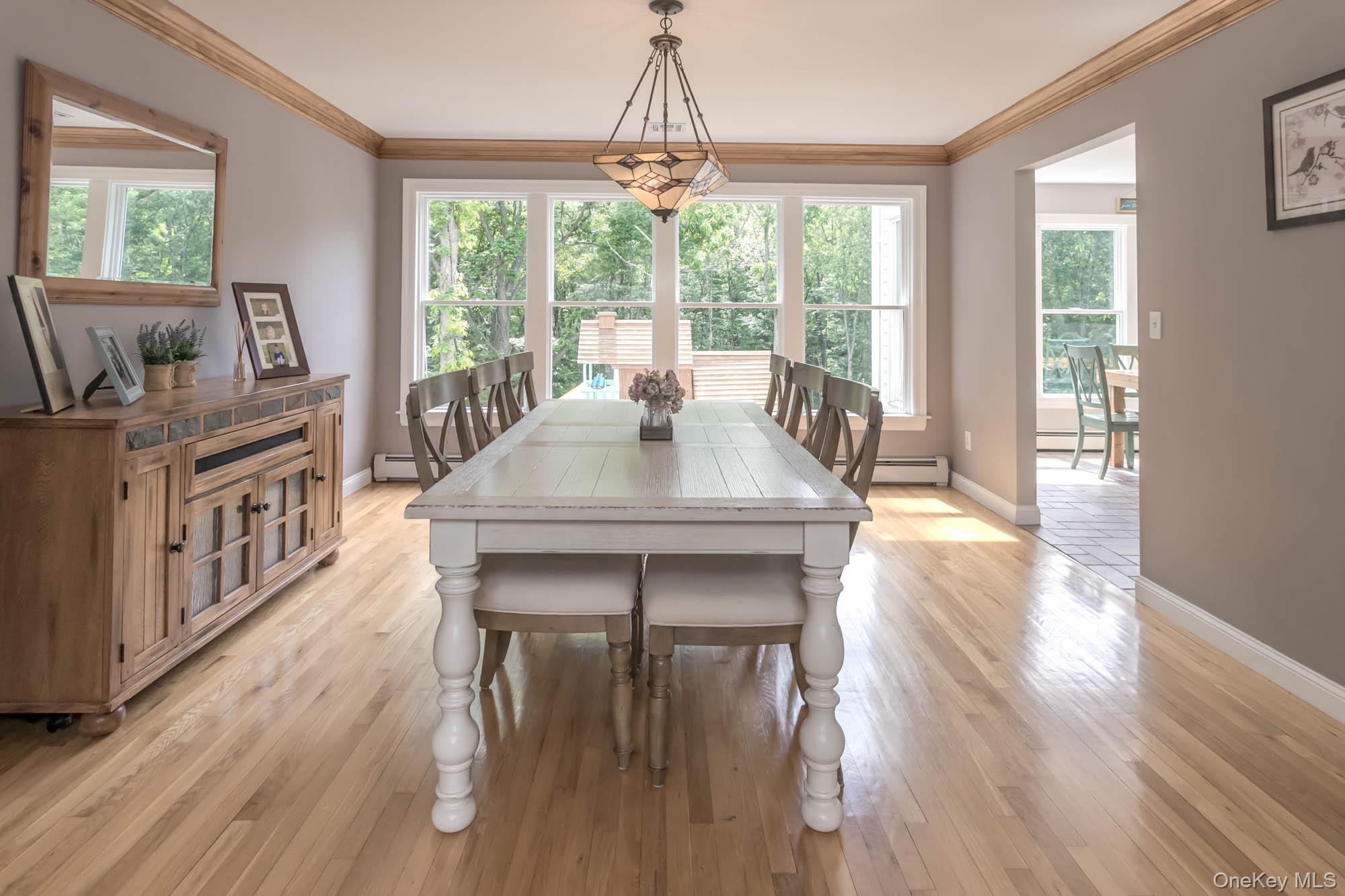102 Beverly Road Chester, NY 10918 - Photo 21 of 49 a dining room with wooden floor a chandelier a wooden table and chairs