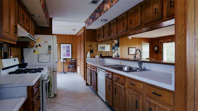 a view of hallway with a large window and chandelier