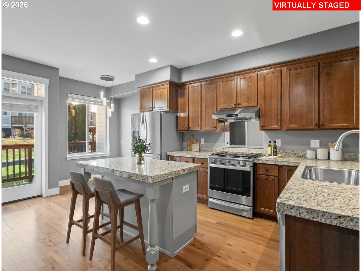 1952 Northeast 48th Way Hillsboro, OR 97124 - Photo 8 of 43 a kitchen with kitchen island granite countertop wooden cabinets and stainless steel appliances