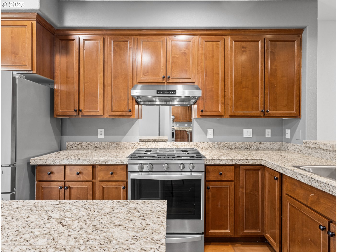 1952 Northeast 48th Way Hillsboro, OR 97124 - Photo 10 of 43 a kitchen with stainless steel appliances granite countertop wooden cabinets stove top oven and sink