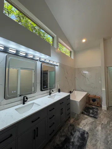 a bathroom with a shower sink vanity mirror and toilet