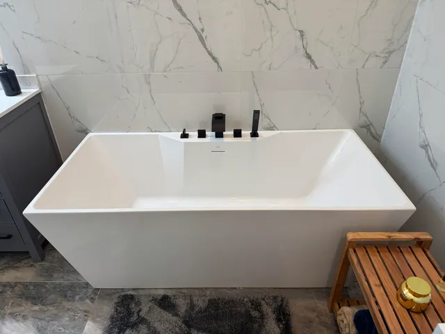 a bedroom with a bed and a flat tv screen on the dresser