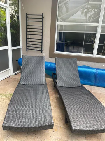 a view of a house with backyard and sitting area
