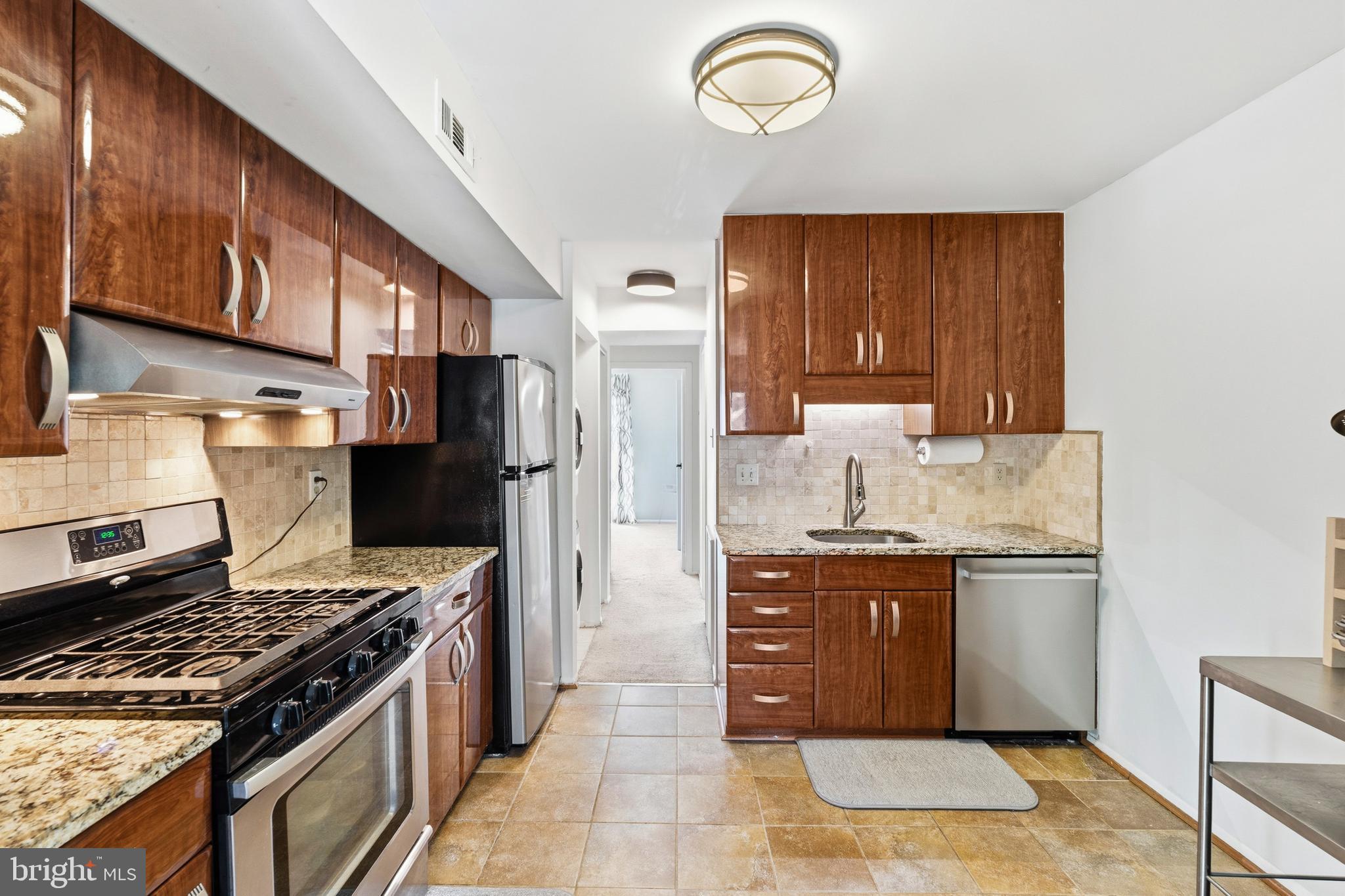 2032 Royal Fern Court, Unit 13/21A Reston, VA 20191 - Photo 14 of 28 a kitchen with stainless steel appliances granite countertop a stove top oven a sink dishwasher and a refrigerator