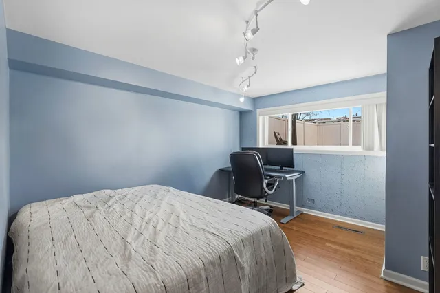 a bedroom with a bed and wooden floor