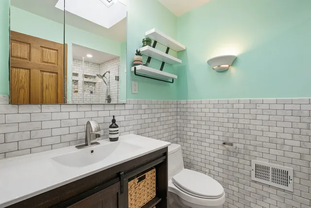 a bathroom with a sink a toilet and mirror