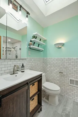 a bathroom with a toilet sink and mirror