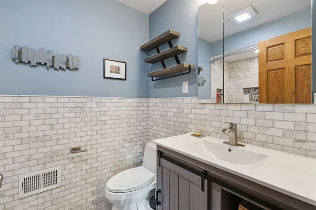 a bathroom with a sink a toilet and mirror