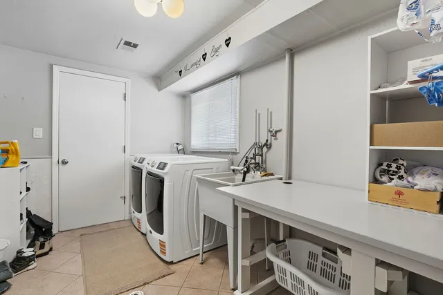 a utility room with sink dryer and washer