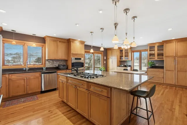 a large kitchen with kitchen island a large counter top space a sink and appliances