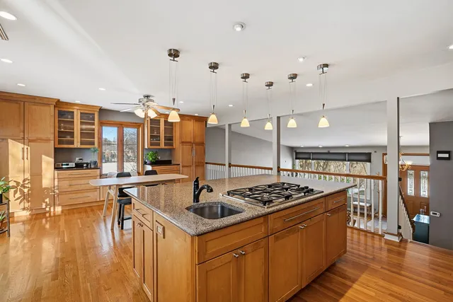 a kitchen with stainless steel appliances a stove a sink dishwasher and white cabinets with wooden floor