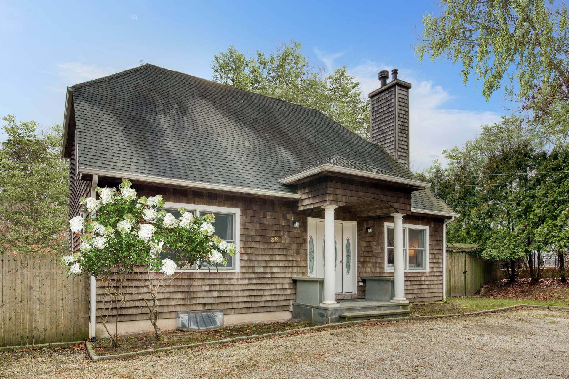 36 Barnes Avenue East Hampton, NY 11937 - Photo 2 of 13 a front view of a house with a garden