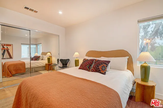 a view of a patio with table and chairs potted plants and floor to ceiling window