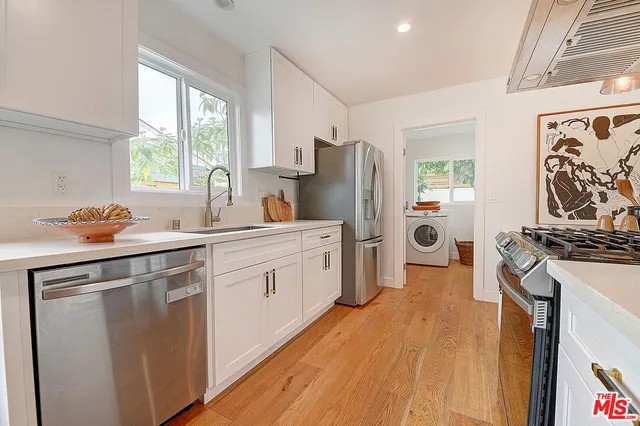 a kitchen with stainless steel appliances granite countertop a stove a sink and a chandelier