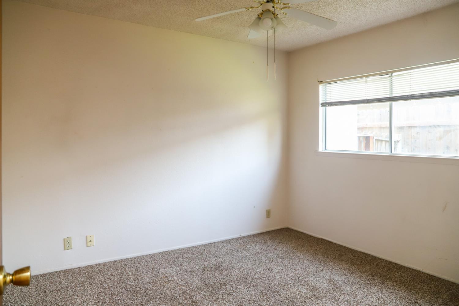 223 South Kady Avenue Reedley, CA 93654 - Photo 15 of 24 an empty room with a chandelier fan and windows