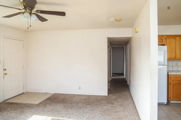 a view of a hallway with a white cabinet and a refrigerator