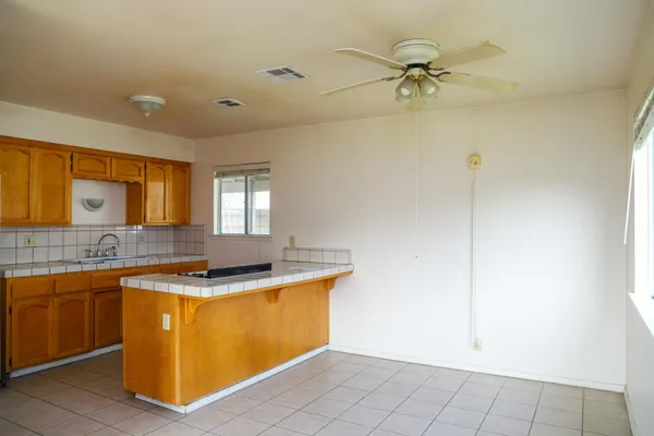 a kitchen with stainless steel appliances a sink a stove a refrigerator cabinets and a dining table