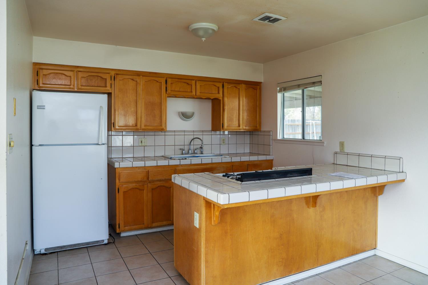 223 South Kady Avenue Reedley, CA 93654 - Photo 8 of 24 a kitchen with a sink a refrigerator and window