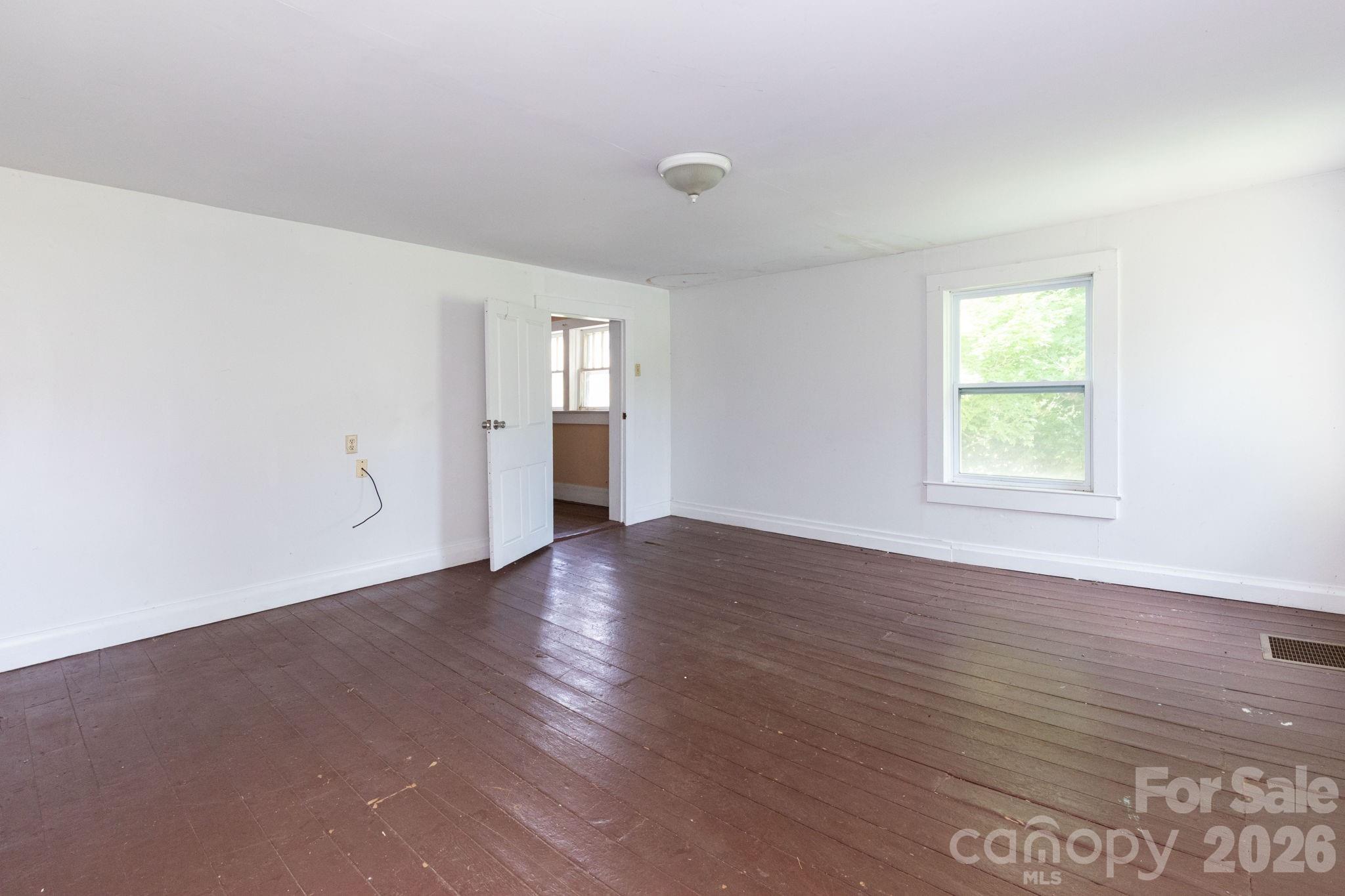4085 Jacks Creek Road Burnsville, NC 28714 - Photo 21 of 24 an empty room with wooden floor and windows