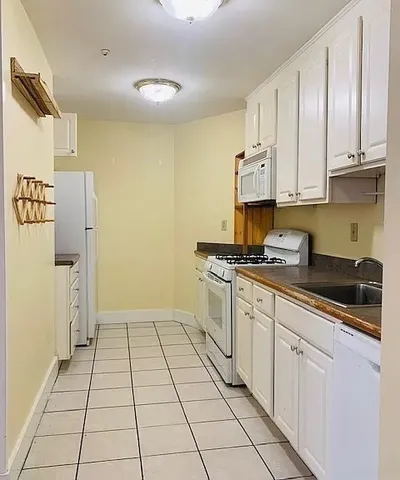 a kitchen with stainless steel appliances granite countertop a refrigerator and a stove