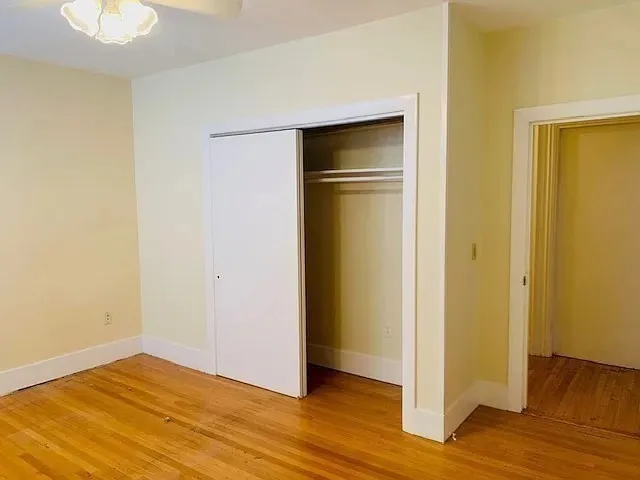 a view of empty room with wooden floor and closet