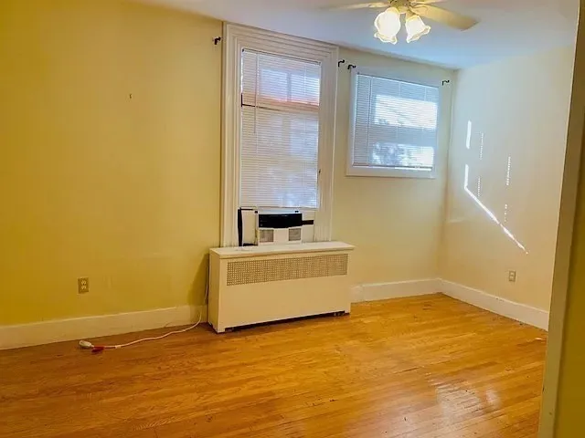 a view of a room with wooden floor and a window