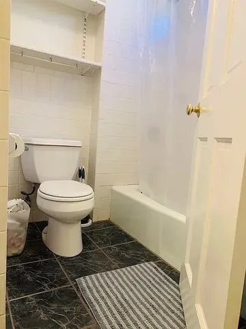 a bathroom with a toilet and a shower