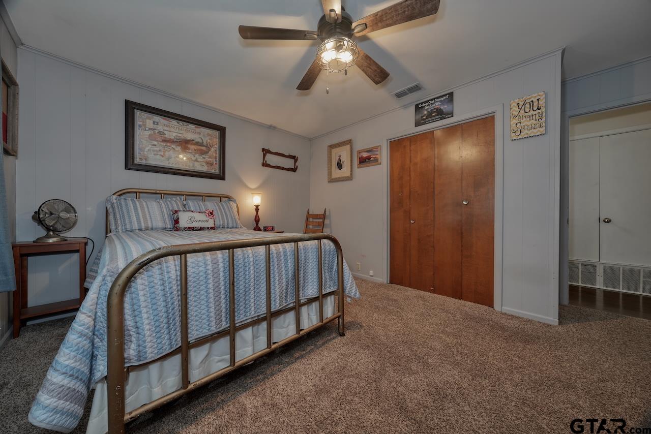 11656 Constantine Avenue Tyler, TX 75708 - Photo 18 of 26 a bedroom with a bed and a chandelier