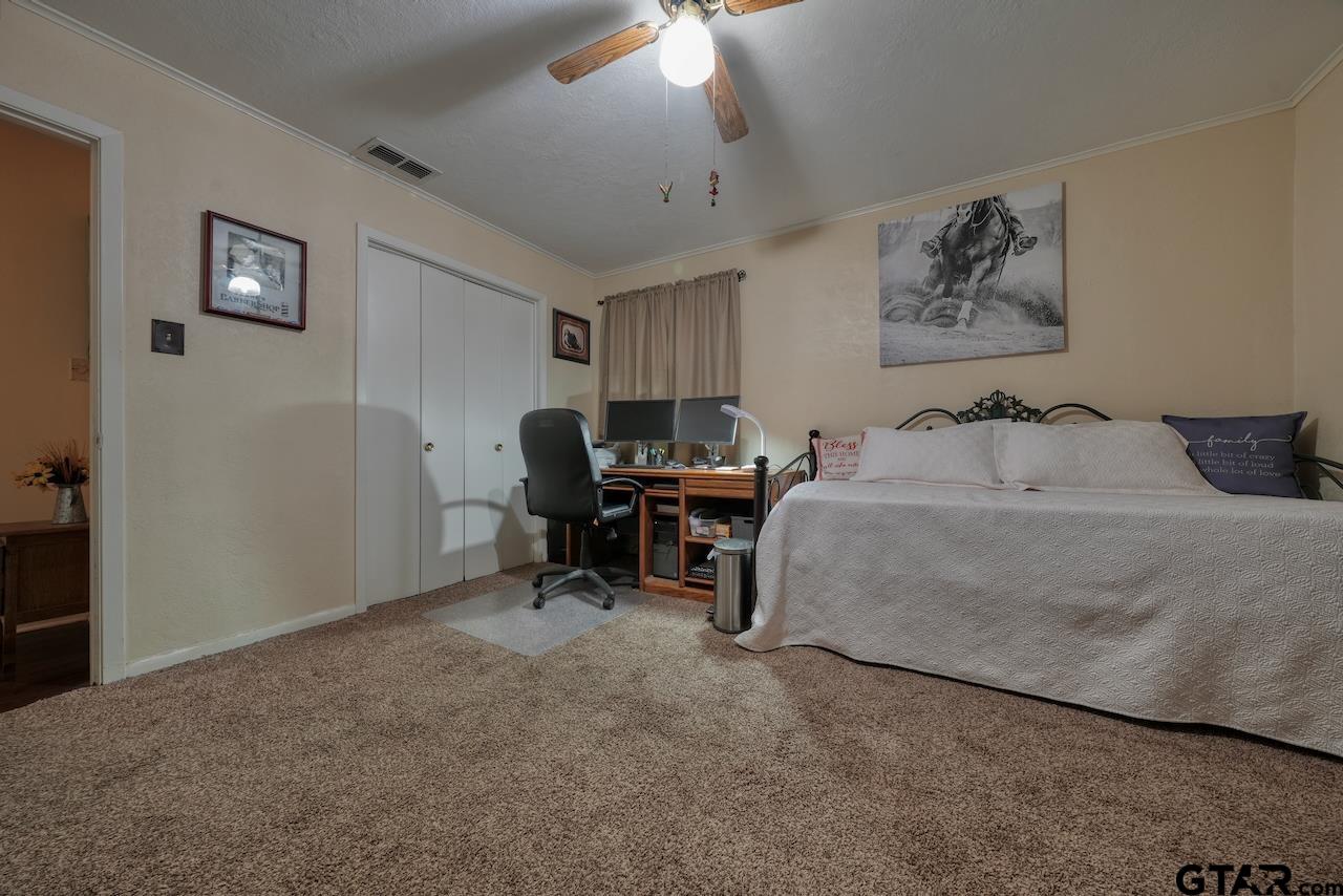 11656 Constantine Avenue Tyler, TX 75708 - Photo 20 of 26 a bedroom with bed and a chandelier