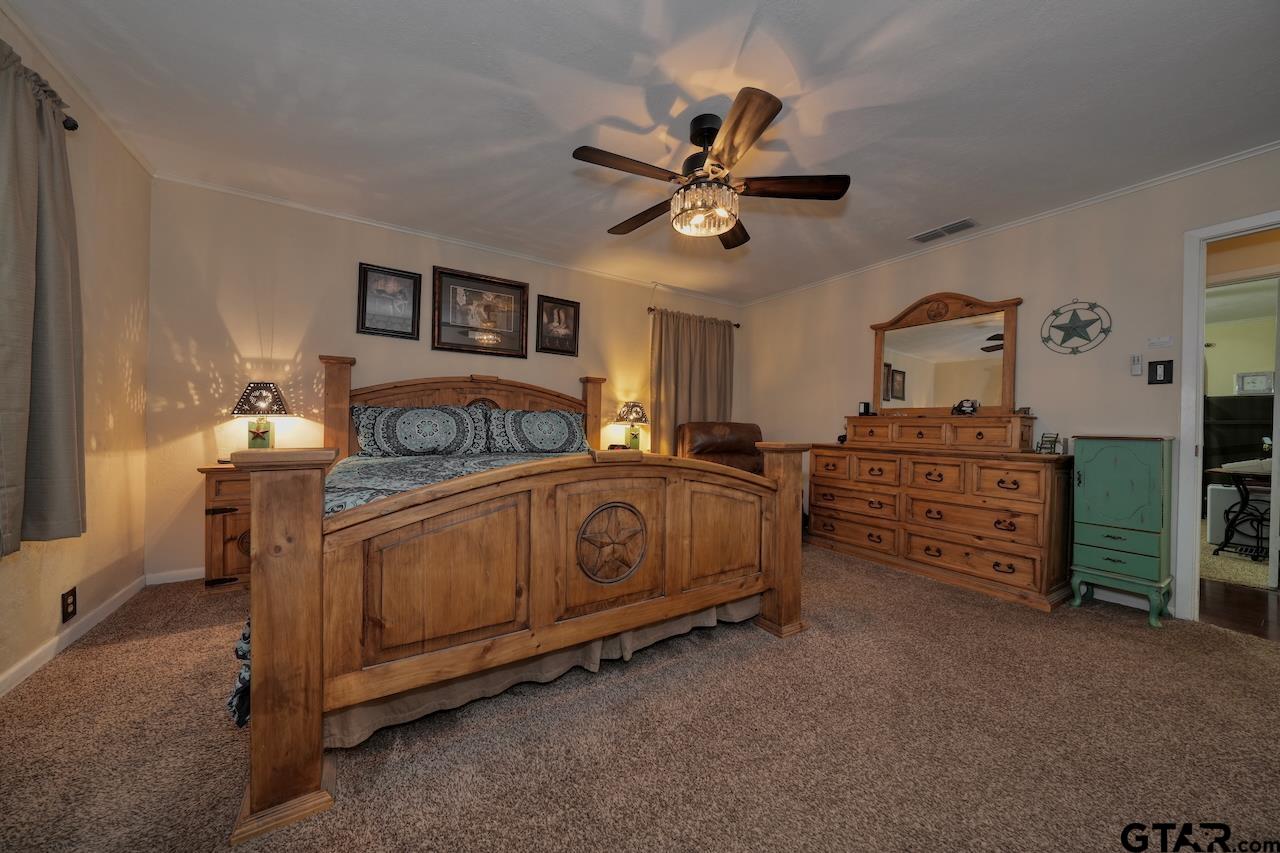 11656 Constantine Avenue Tyler, TX 75708 - Photo 22 of 26 a bedroom with a bed and a chandelier