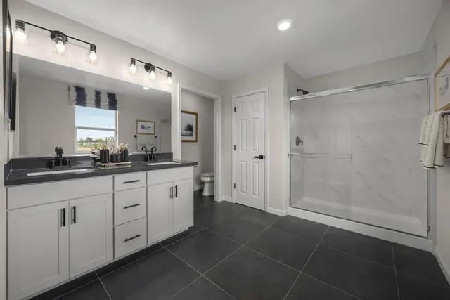 a spacious bathroom with a mirror a shower and a sink