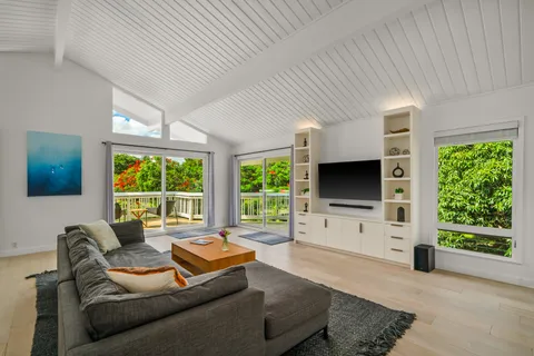 a living room with furniture a flat screen tv and a large window