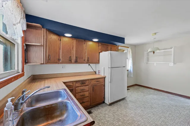 a view of a kitchen with a stove fridge and wooden floor