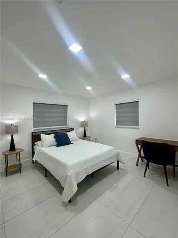 a bedroom with a bed a lamp and a dresser