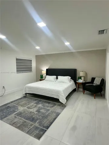 a spacious bedroom with a bed a couch and a window