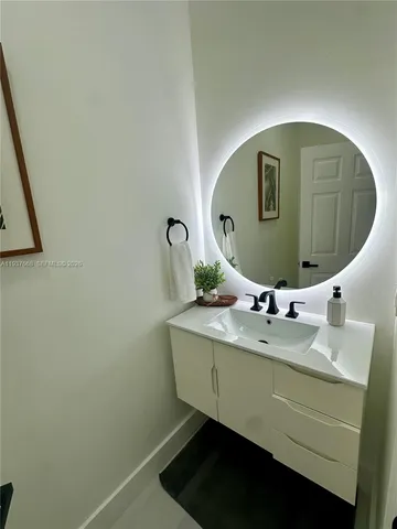 a bathroom with a sink mirror and vanity