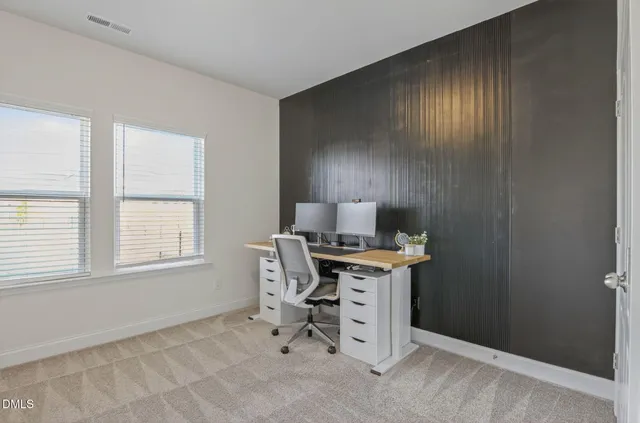 a bedroom with a bed flat screen tv and windows