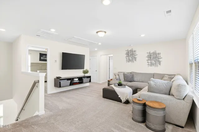 a bedroom with a bed and a flat tv screen on dresser