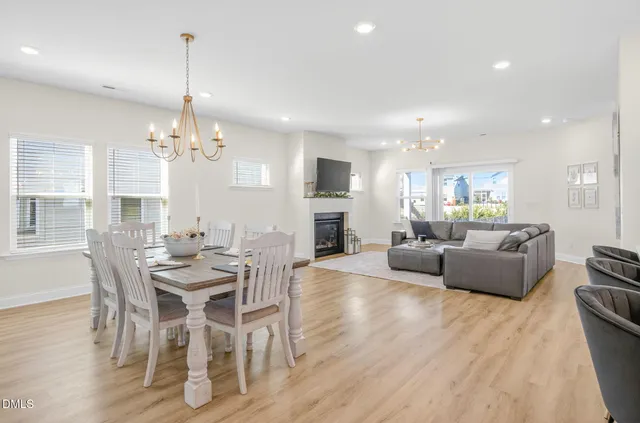 a kitchen with stainless steel appliances granite countertop a dining table chairs stove refrigerator and cabinets