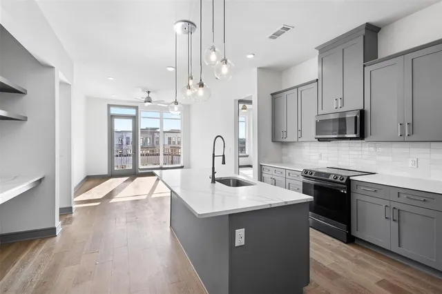 a kitchen with stainless steel appliances granite countertop a sink stove and refrigerator