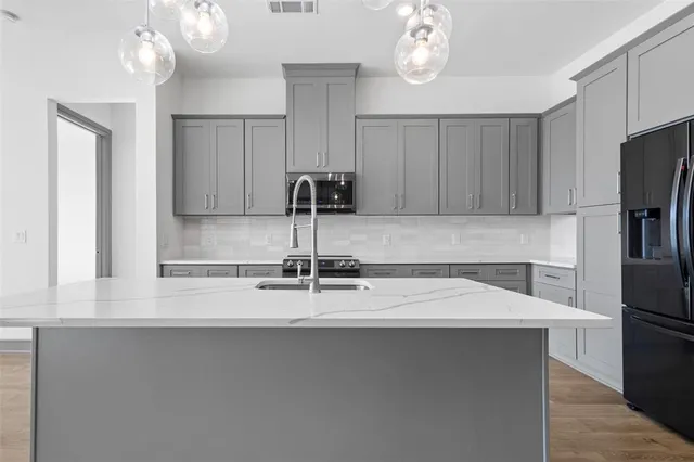 a kitchen with stainless steel appliances a sink and a refrigerator