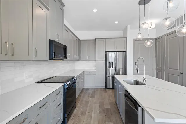 a kitchen with a sink stainless steel appliances and cabinets