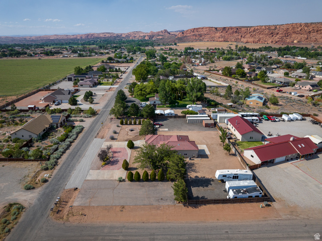 4297 Beeman Road Moab, UT 84532 - Photo 50 of 59 Expansive parcel featuring multiple buildings with red roofs, a large gravel lot, and paved access