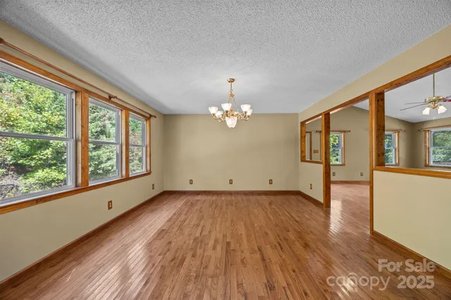 a view of a livingroom with a furniture wooden floor and chandelier