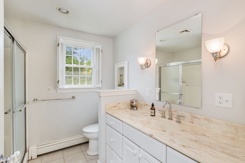 44 Buccaneer Way Mashpee, MA 02649 - Photo 27 of 39 a bathroom with a granite countertop sink a toilet and a mirror