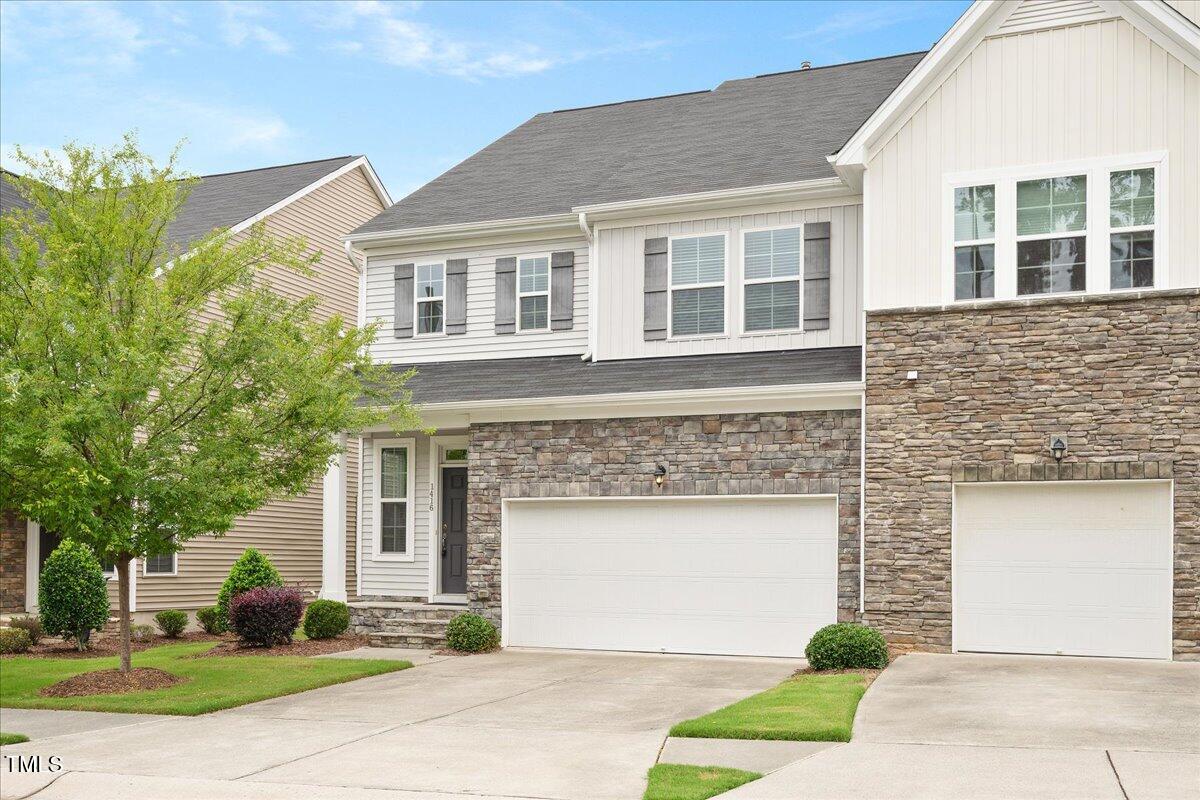 a front view of a house with a yard and garage