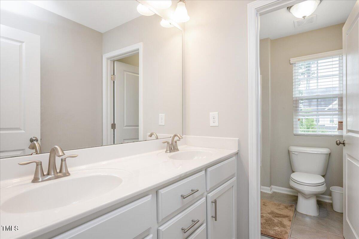 1416 Southpoint Trail Durham, NC 27713 - Photo 21 of 26 a bathroom with a sink a toilet and a mirror