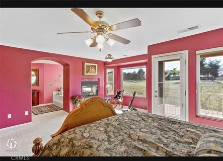 a bedroom with a bed and large windows